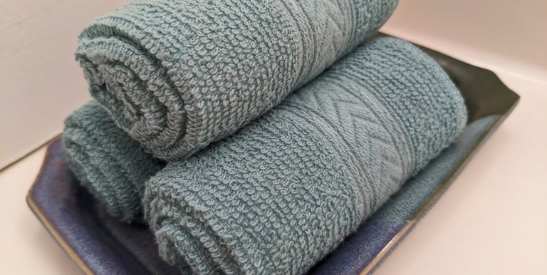 rolled up stack of light blue hand towels