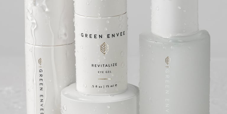 green envee skincare products with water splashing on them