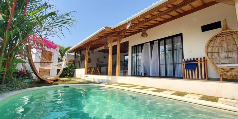 Construction of villas in Bali: residence with swimming pool, wooden terrace and tropical vegetation