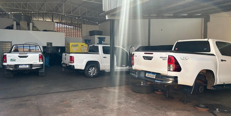 Foto com veículos em manutenção no pátio da empresa