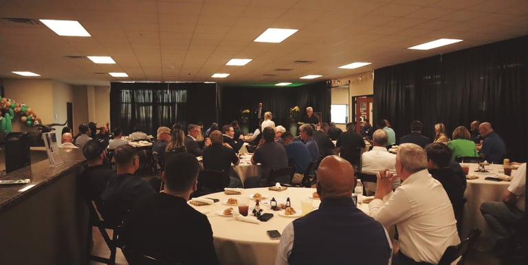 a group of people sitting at tables in a room for event