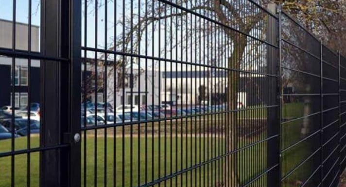 grade de metal na cor preta cercando um estacionamento