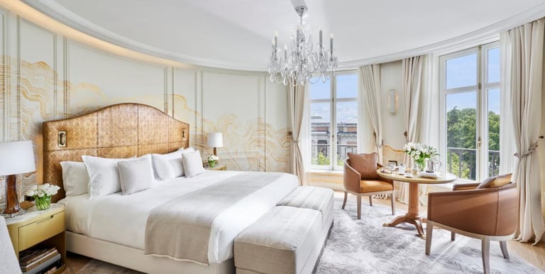 Luxury Suite Bedroom – Spacious suite with a king-size bed, crystal chandelier, and panoramic views.