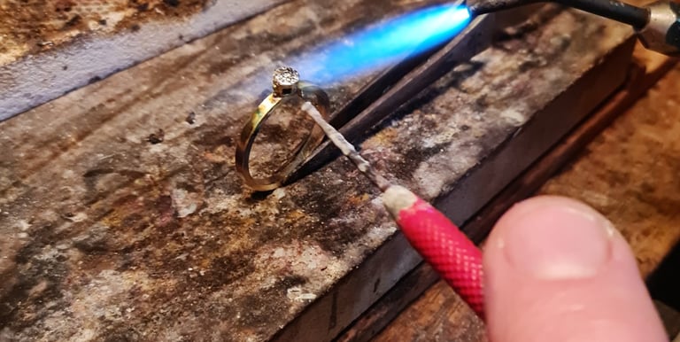 a person holding a small piece of metal with a blue flame