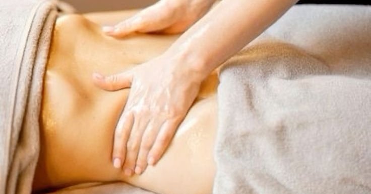massage du ventre dans une ambiance lumineuse et détendue