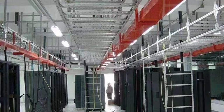 una sala grande con muchos equipos informáticos y escalera de cables y bandeja de cables