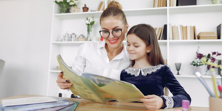Profesora enseñando un libro a una niña