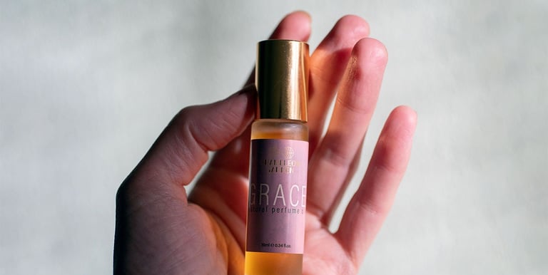 a person holding a bottle of perfume in their hand - Chameleon Garden Perfumery