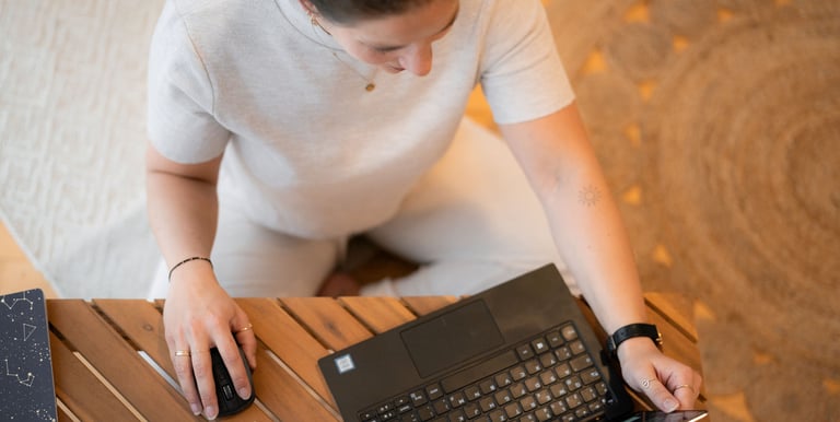 Eine Frau im Schneidersitz auf dem Boden sitzend, arbeitet an ihren Stressmanagement Beratungsangebo