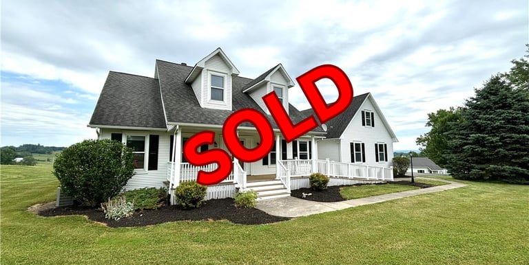 a sold sign for a home in a residential neighborhood
