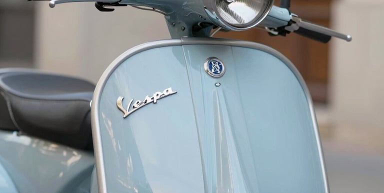 Close-up of a sleek electric Vespa's handlebar and vintage design details under natural light.