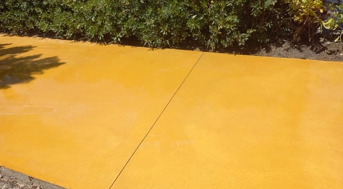 Hormigón pulido color amarillo para camino exterior.