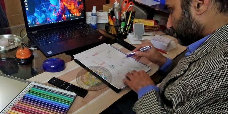 Dr. Prabal Frank Nandwani analyzing a Vastu chart with precision drafting tools