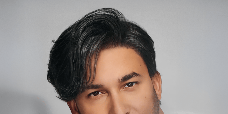 Homme aux cheveux noirs coiffés sur le côté avec une coupe moderne et structurée.