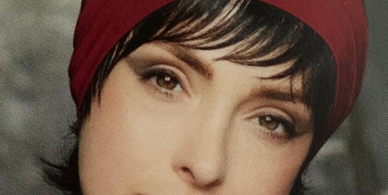 Femme portant une frange courte et un foulard rouge sur la tête.