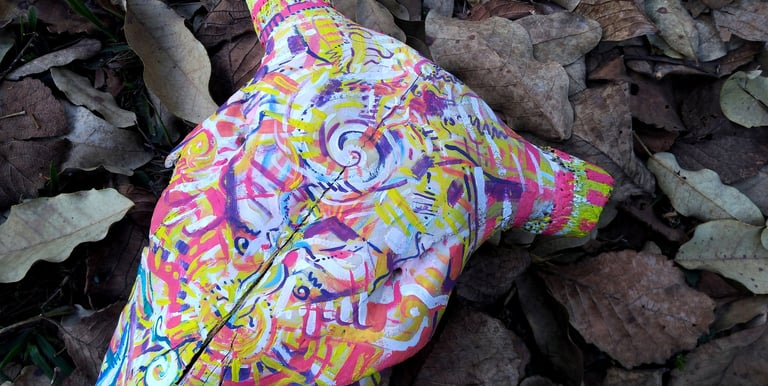 peinture aux couleurs vives sur un crane  sur un lit de feuilles mortes
