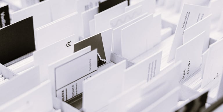 Photo en noir et blanc de plusieurs cartes de visite et supports triés