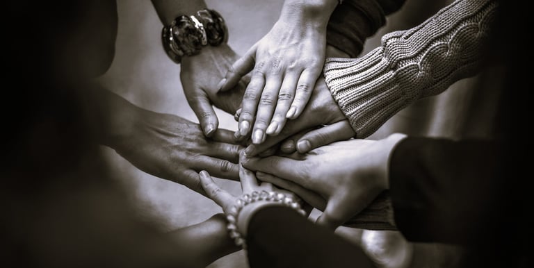 Plusieurs mains rassemblées au centre, symboles de cohésion et de relations sociales