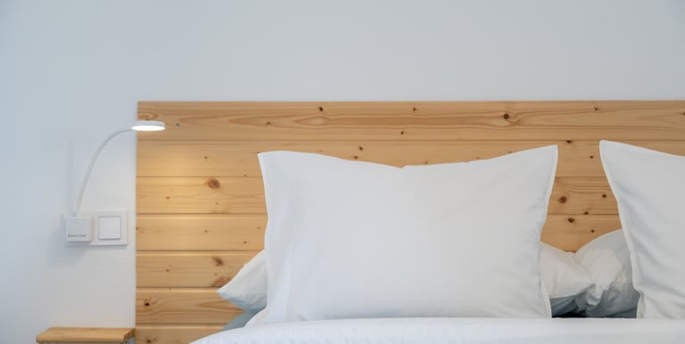a bed with a wooden headboard and a lamp