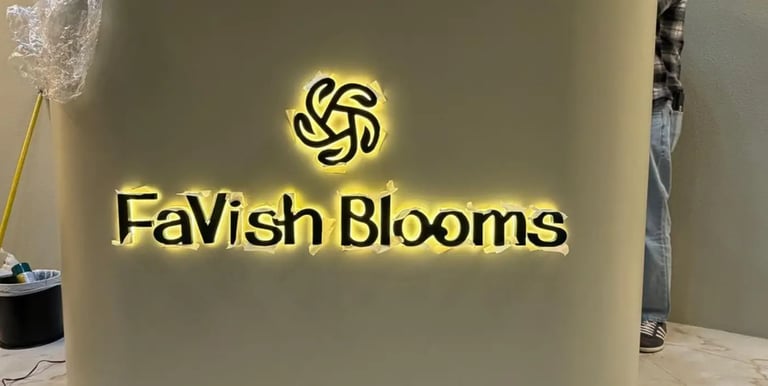Illuminated FaVish Blooms back-lit channel letter office signage being installed on a curved wall.