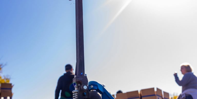 uma paleteira azul com um homem em pé ao lado dela