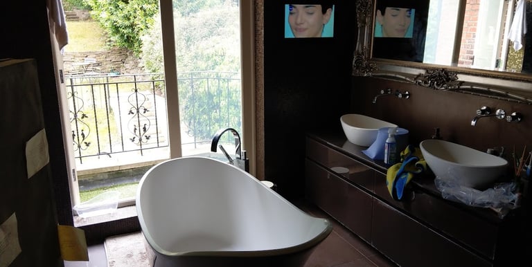 MountMyTV - 32" Aquavision TV mounted on a wall in a tiled bathroom