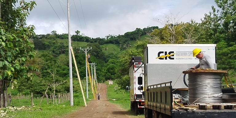 instalacion de postes o tendido electrico en una zona residencial, con camiones en Costa Rica