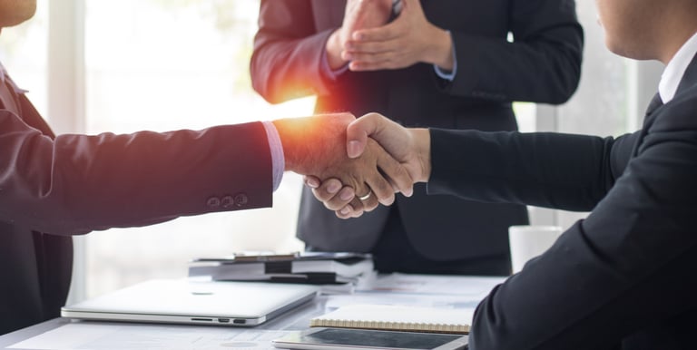 Two business professionals shaking hands to finalize a business services deal