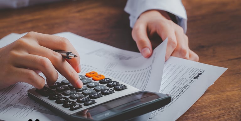 Person using a calculator to work on tax documents.