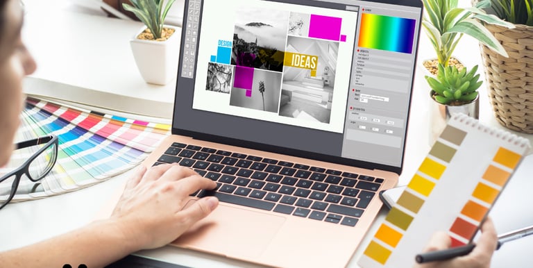 Designer working on laptop, selecting colors and creating graphic layouts for branding and marketing