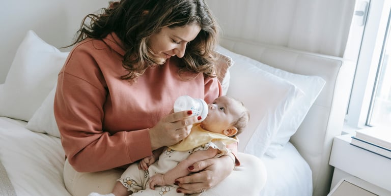 a woman breastfeeding a baby in a bed