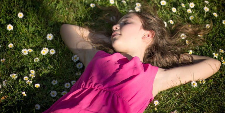 fillette habillée en rose dans un pré