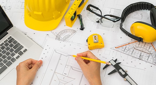a person is working on a laptop computer and a yellow helmet