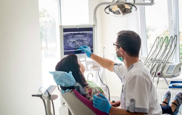 a dentist explaining the root canal and crown treatment at  in white castle dental clinic katraj 
