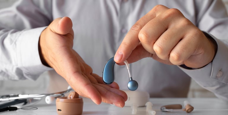 a man holding a pair of ear buds in his hands