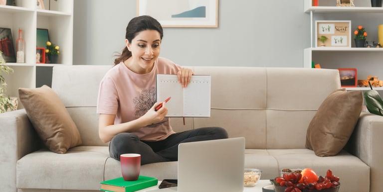 a woman sitting on a couch with a notebook and a notebook