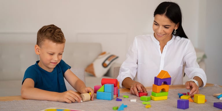 a woman and a boy playing with blocks
