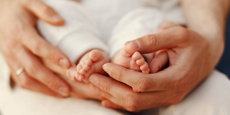 mains maman et papa qui soutiennent pieds bébé pour consultation sommeil complet sophie jobbé duval