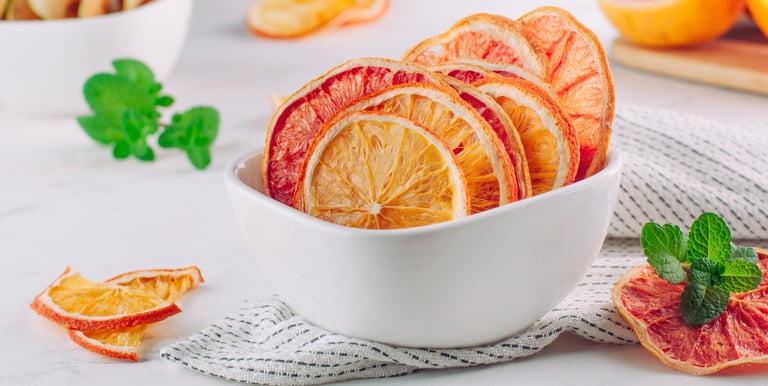 Bowl de cerámica con rodajas deshidratadas de pomelo, naranja y limón.