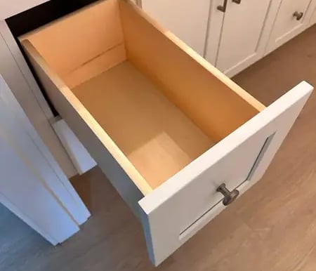 Open box inside a white shaker cabinet, showing solid wood construction and smooth finish.