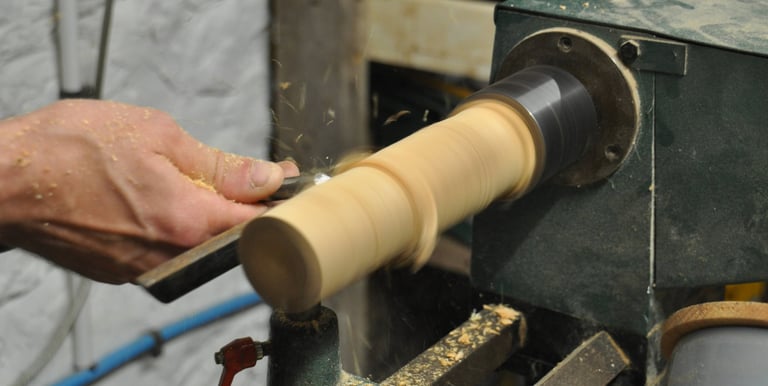 Close-up of a column of wood being turned on a lathe