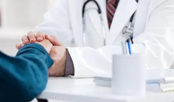 consultation personnalisée un médecin tient la main de son patient