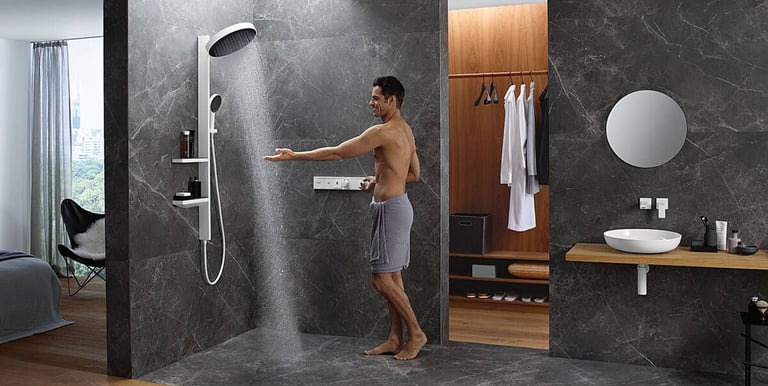 a man standing in a bathroom with a shower head