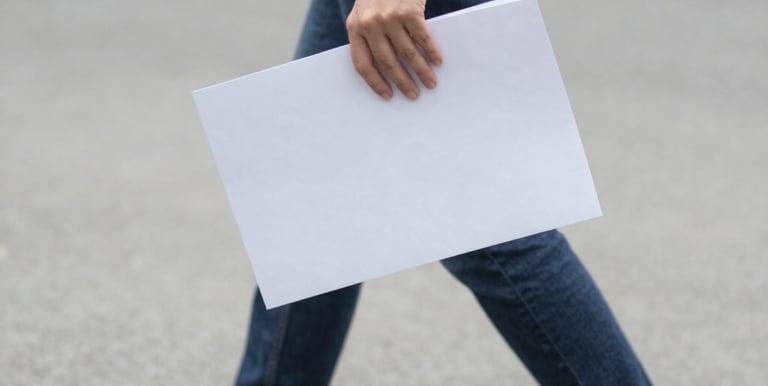 A close-up of hands typing code with website wireframes on a screen.