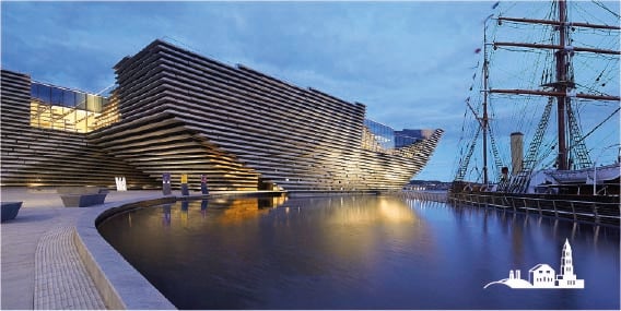 The V&A Dundee museum's modern architecture at night next to the historic RRS Discovery ship in Scotland.