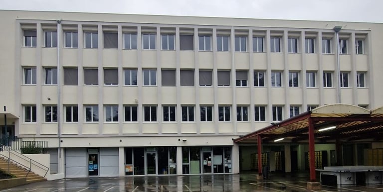 a building with a bunch of windows and a bench in front of it
