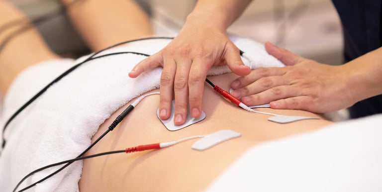 Profissional da saúde posicionando eletrodos do aparelho TENS nas costas do paciente