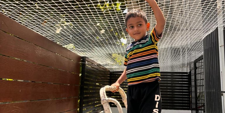 Children playing safely behind a well-fitted safety net on a staircase.