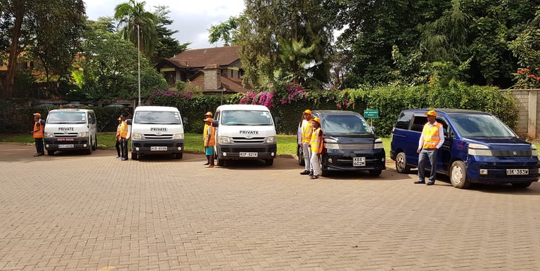 Professional transport crew at Vanna Ventures standing with a fleet of private minivans and vans