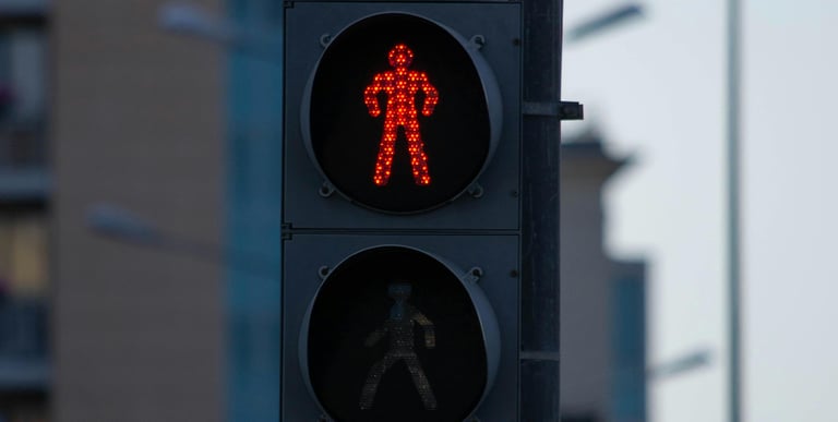 Rood stilstaand verkeerslichtmannetje als symbool voor waarschuwingssignalen en twijfel.